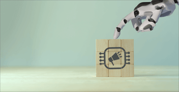 Illustration shows a robot hand touching an assemblage of wooden blocks in a 3-by-3 grid. Printed on the blocks is a simple picture of a megaphone.